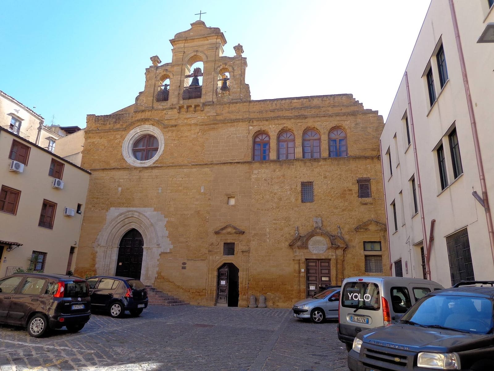 die Steinfassade des Klosters Santo Spirito, mit dem Glockengiebel und dem gotischen Portal, am Ende seines Hofes