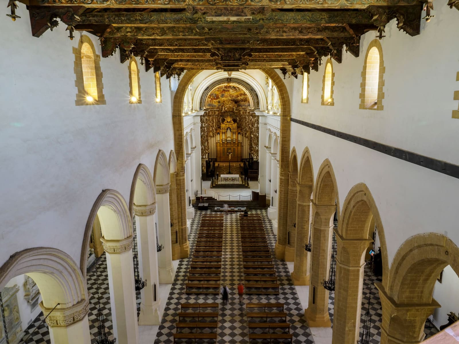la navata di San Gerlando vista dall'alto, fra le arcate a sesto acuto, con il pavimento a scacchi e il coro in fondo