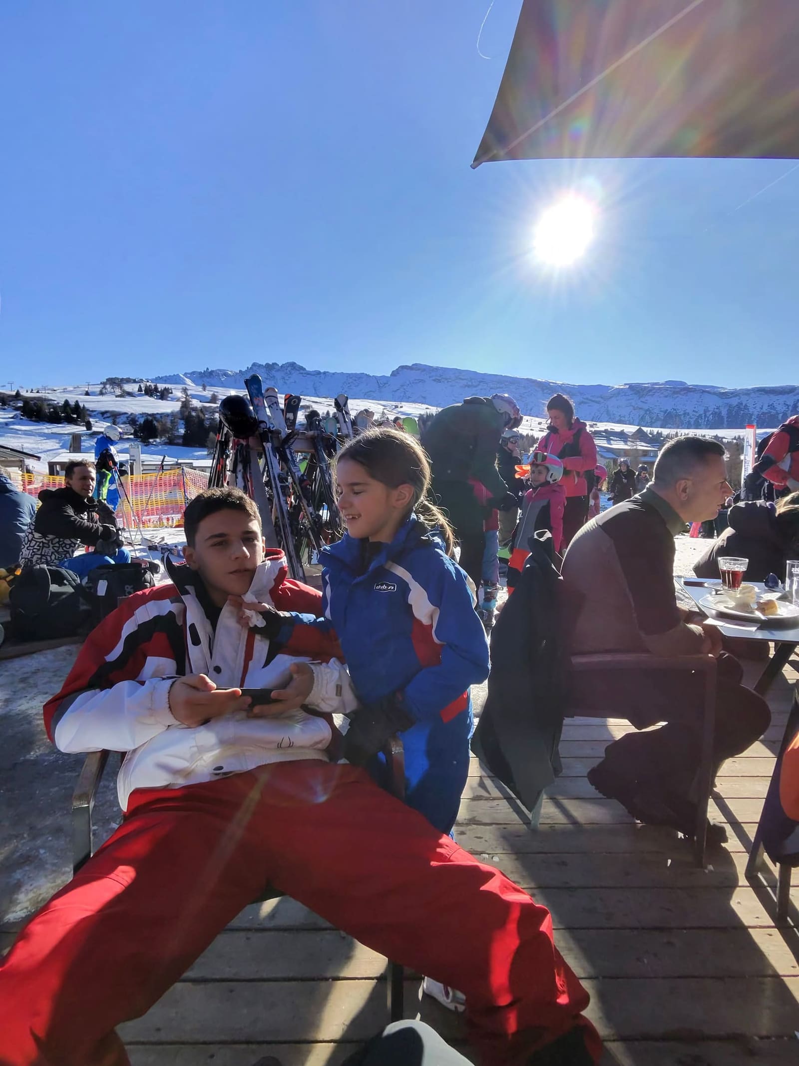 Gabriele e Letizia sulla terrazza al sole, con la rastrelliera degli sci alle spalle