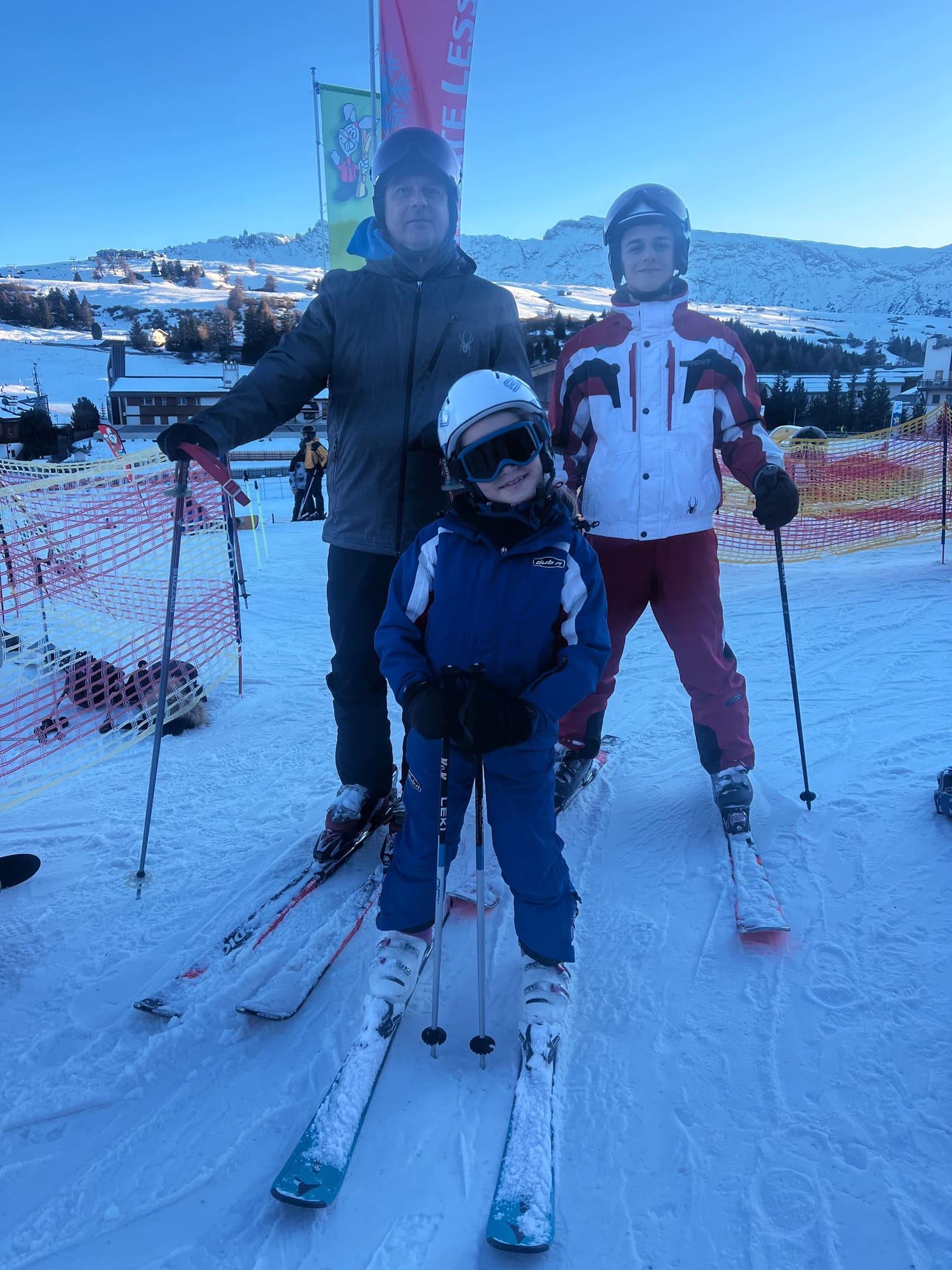 pronti per la pista con gli sci ai piedi, Letizia in mezzo con il casco bianco e Gabriele a destra