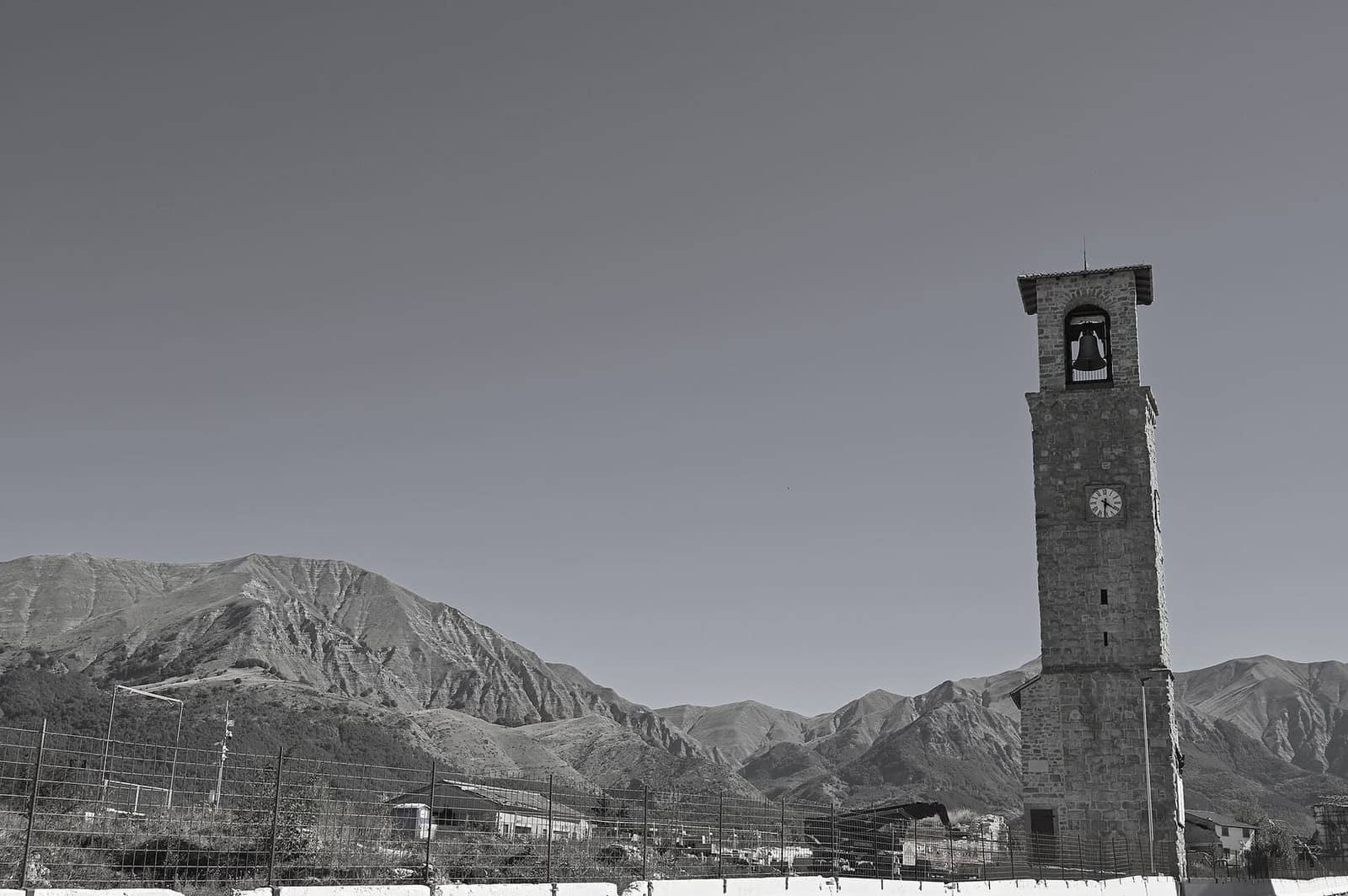 der Stadtturm im September 2026, mit den Bergen, die das Becken von Amatrice schließen