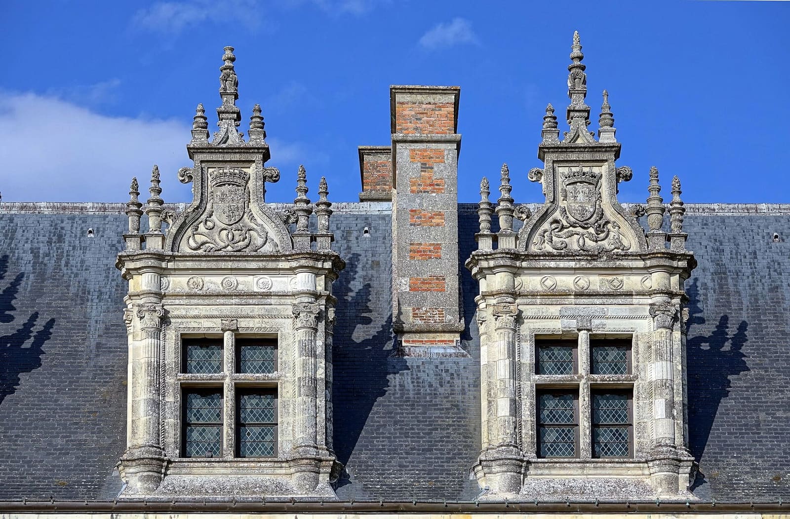 two carved dormers on the château's slate roof