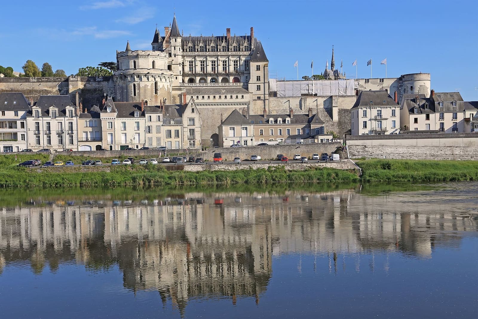 the château above the riverside houses, reflected in the Loire under a blue sky