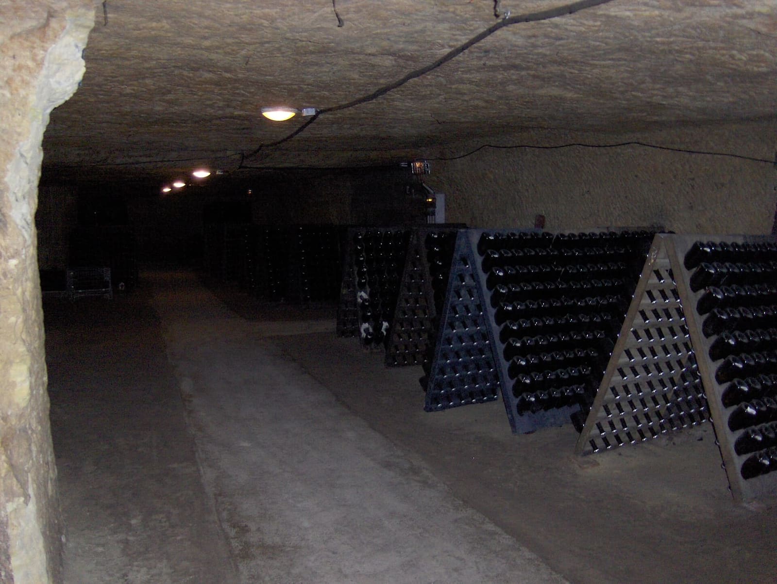 bottles on racks in a cellar carved into the limestone, in the Vouvray area