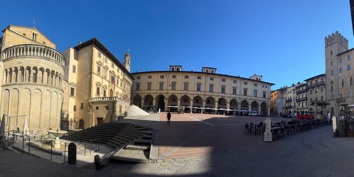l'abside della Pieve, il porticato del Palazzo delle Logge e il piano inclinato di Piazza Grande