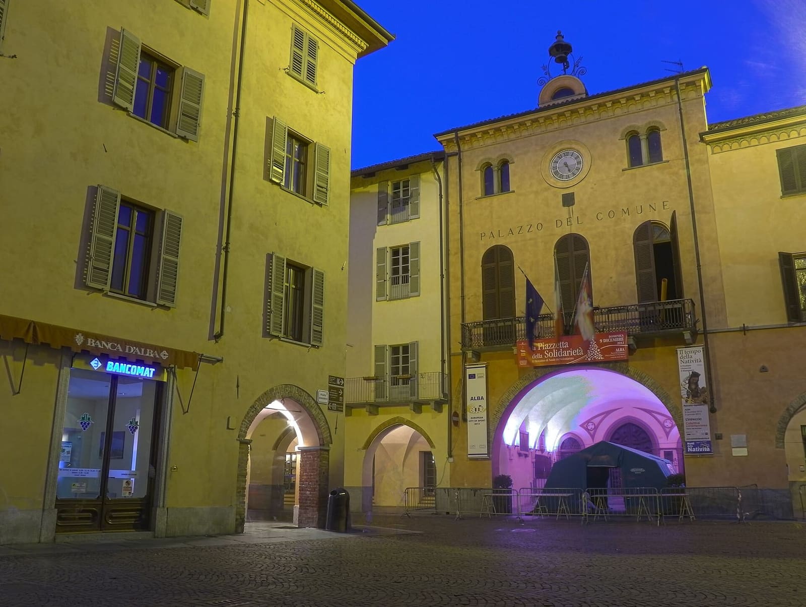 the Palazzo Comunale lit up in the evening, with the arch of the arcade open onto the square