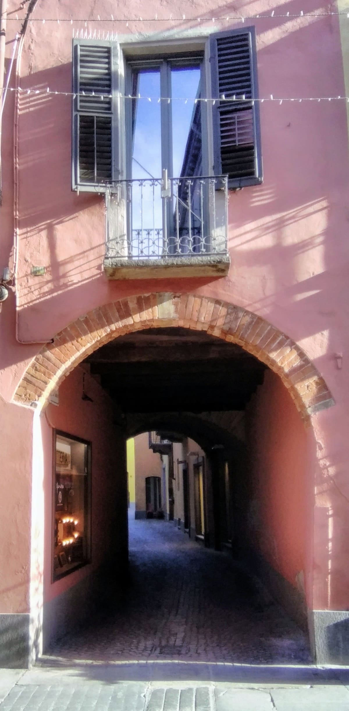 an arched passage under a pink house, among the streets of the old town