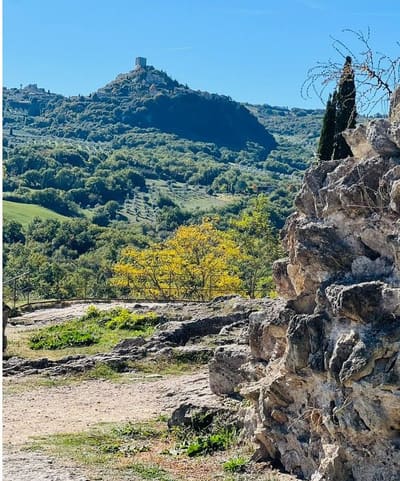 dal bordo di travertino del parco, il borgo e la torre sulla collina di fronte