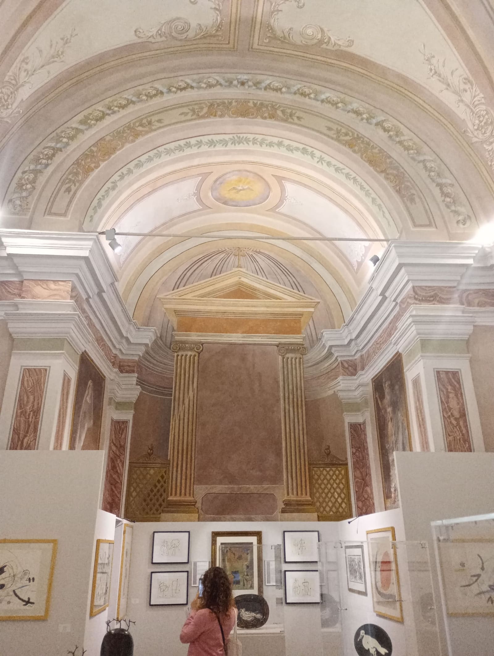 dentro Sant'Agostino, le volte decorate sopra i pannelli di una mostra