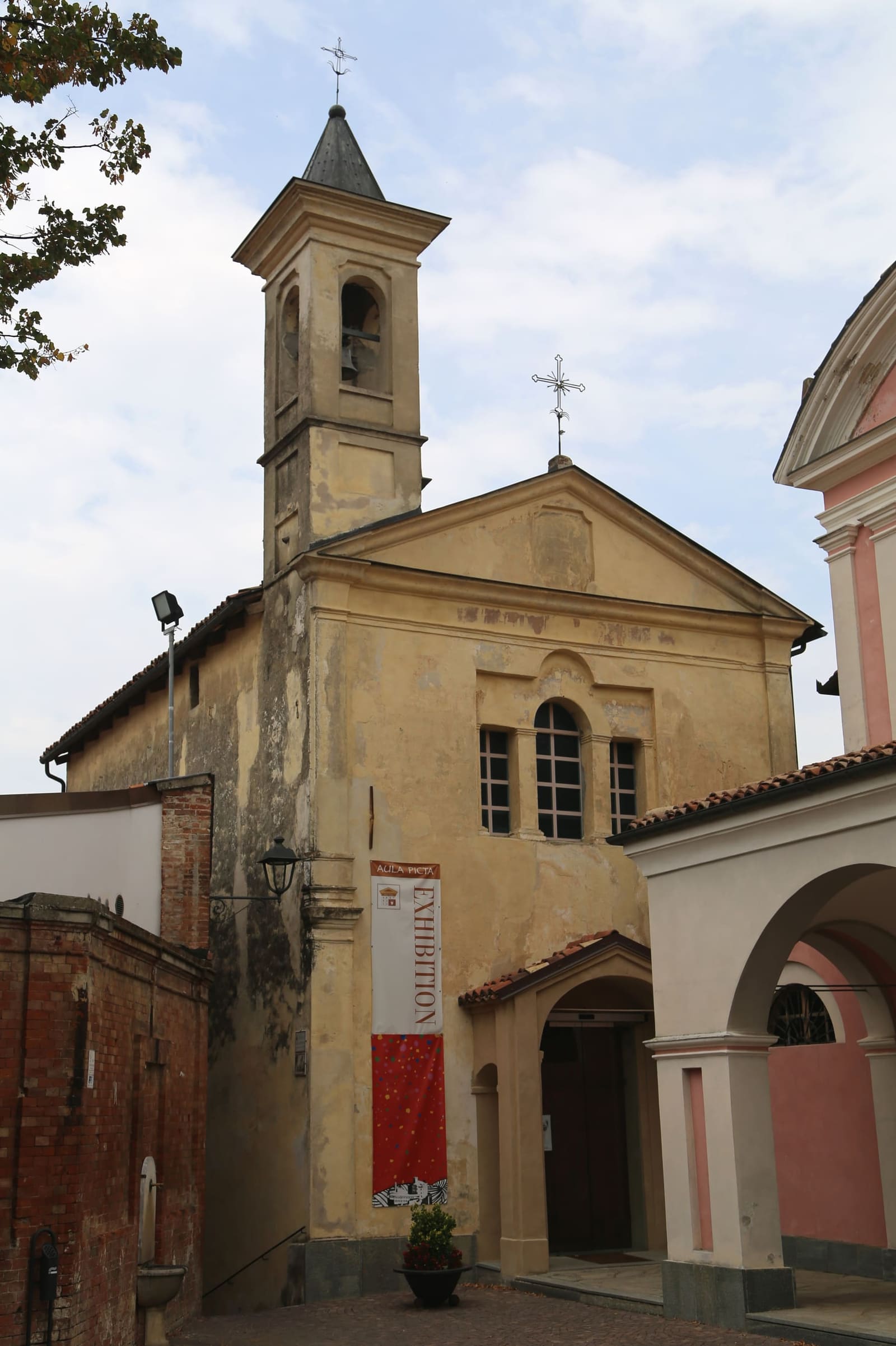 la facciata di Sant'Agostino con il campanile a punta e lo striscione di una mostra