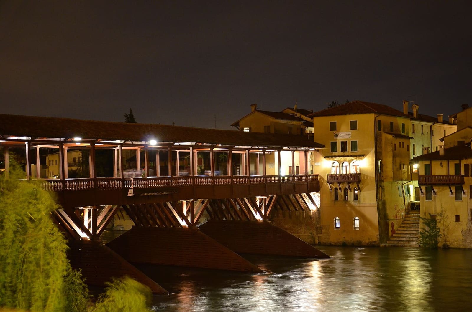 il Ponte Vecchio illuminato di notte, con le case sulla riva