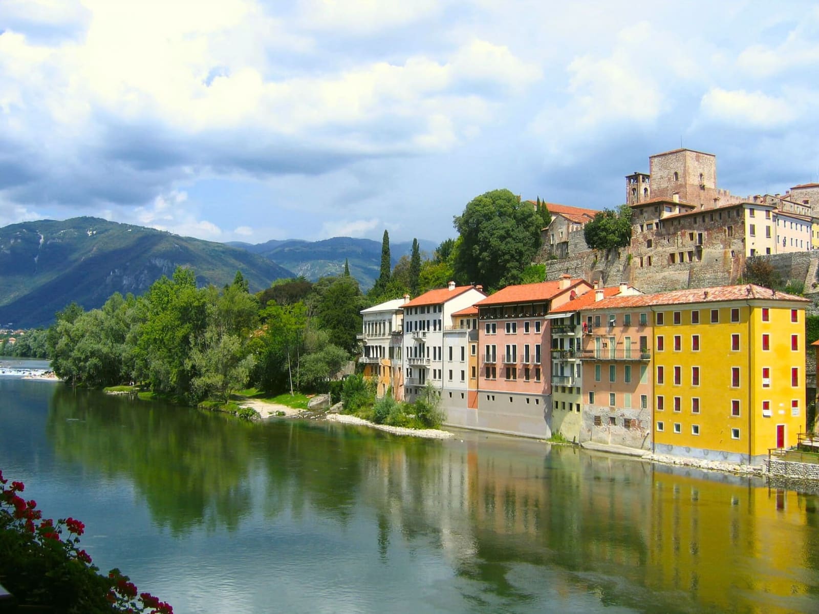 le case colorate sulla riva del Brenta viste dal Ponte Vecchio, con il castello in alto
