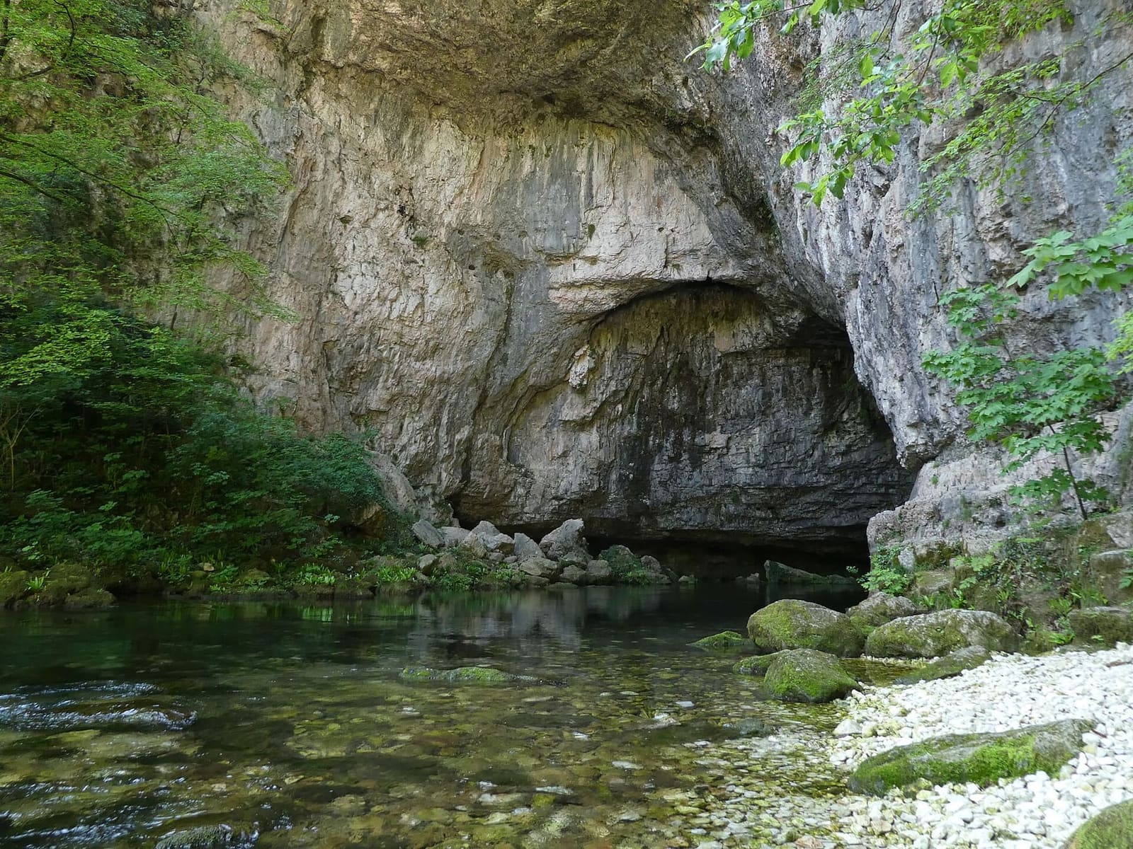 una delle grotte di Oliero, con l'acqua che esce limpida dalla roccia