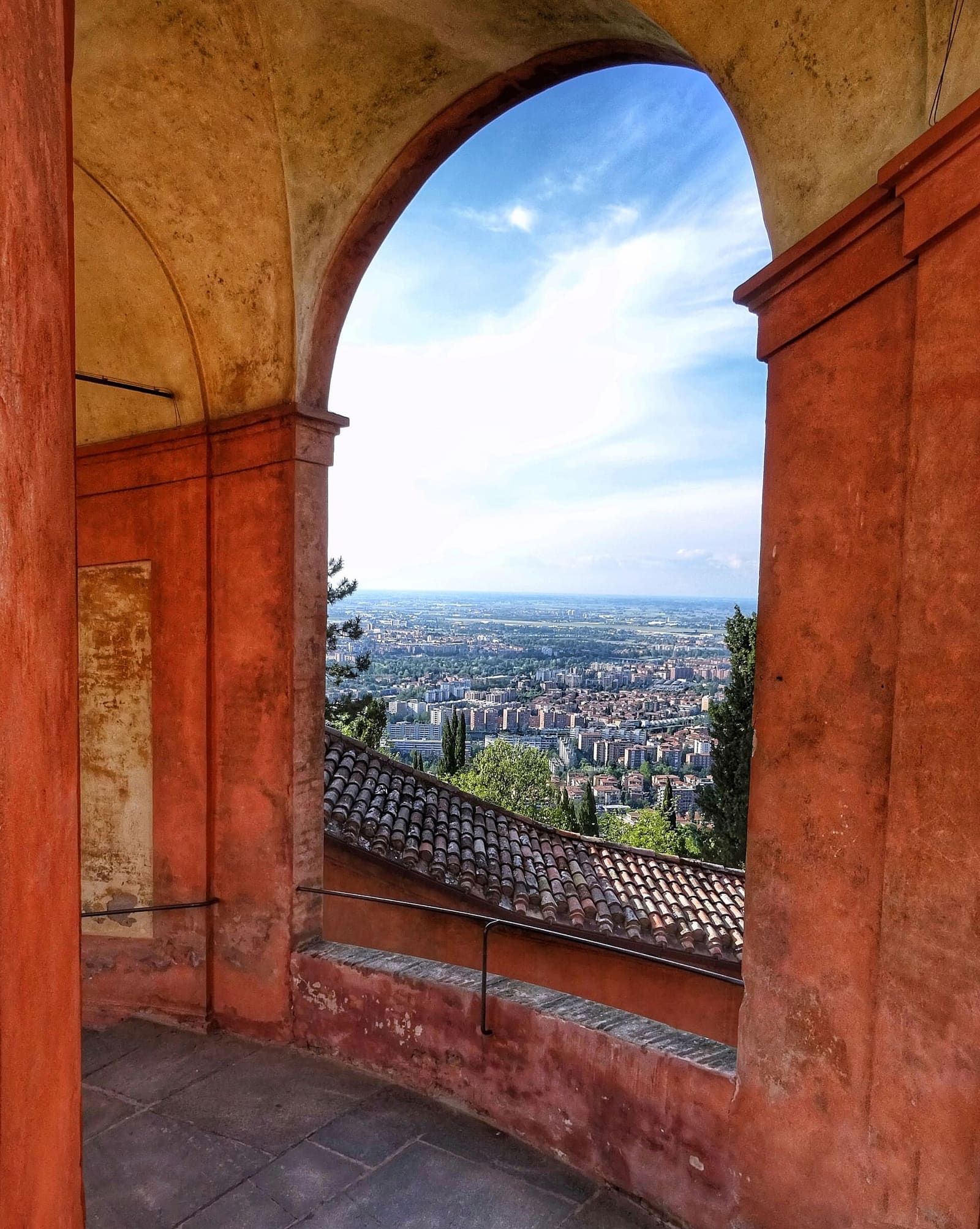 un arco del portico di San Luca aperto sulla città e sulla pianura