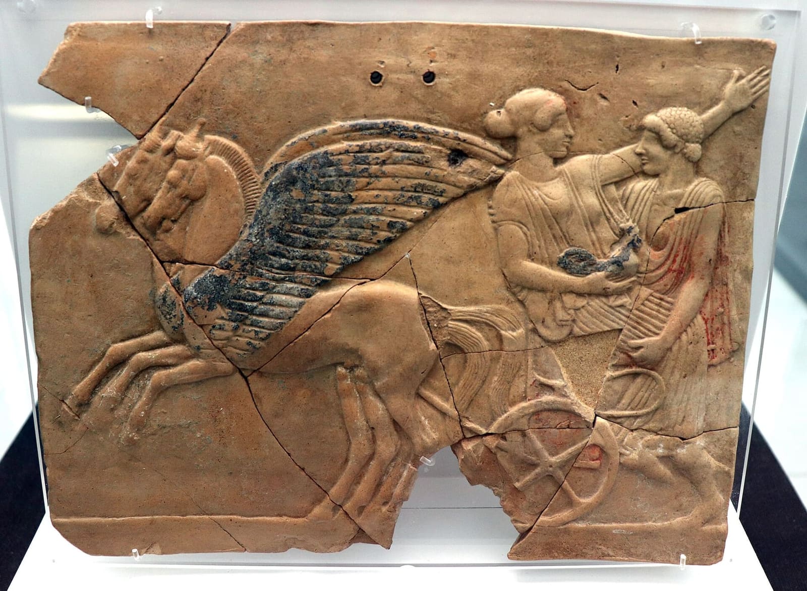 un pinax di Locri con Ade che rapisce Persefone sul carro