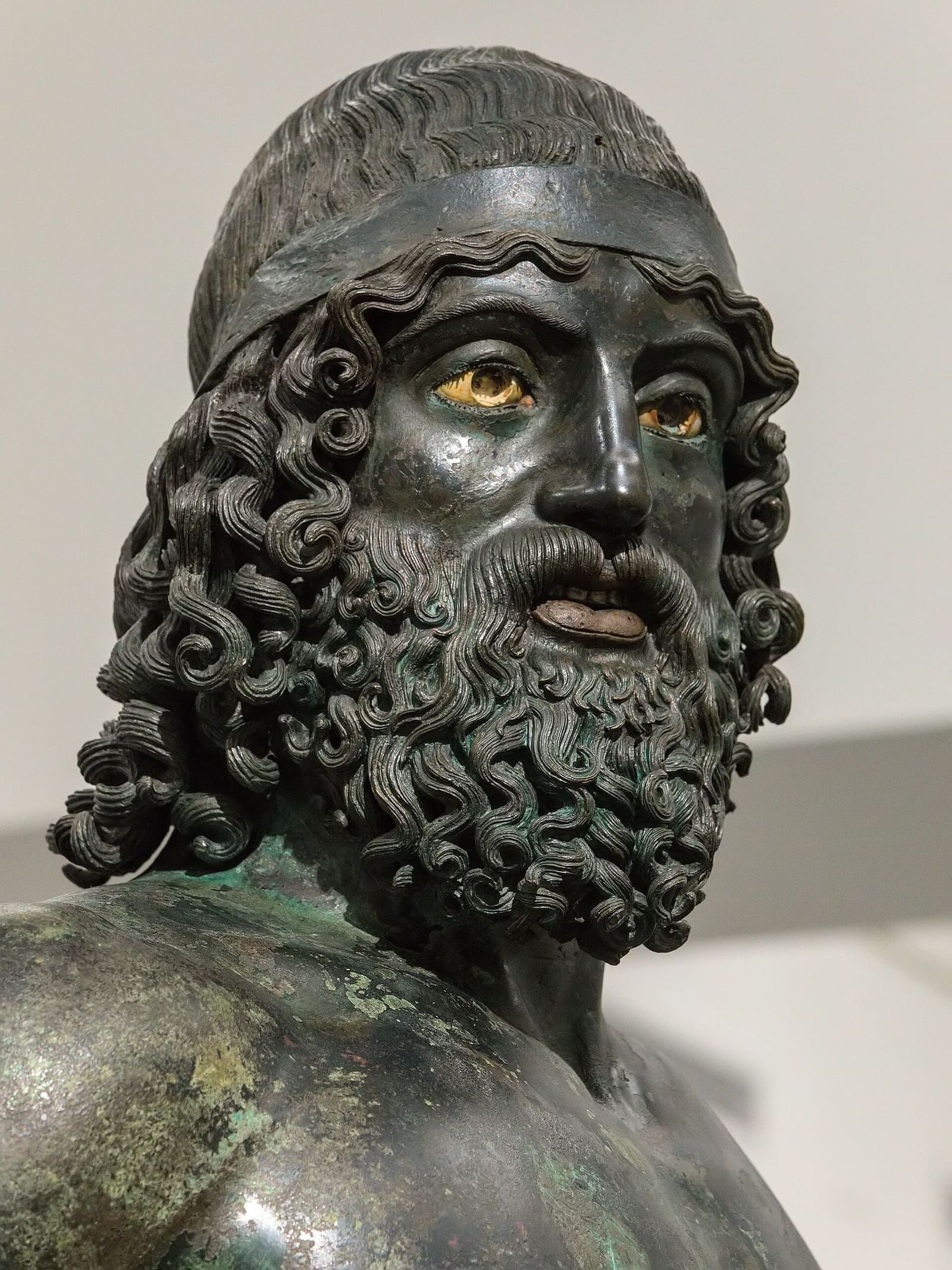 il volto del Bronzo A, con gli occhi chiari e le labbra di rame