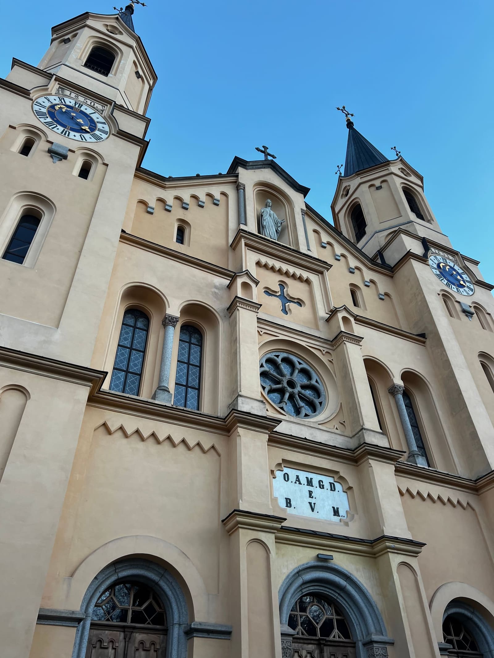 la facciata della chiesa di Santa Maria Assunta, i due campanili e gli orologi blu