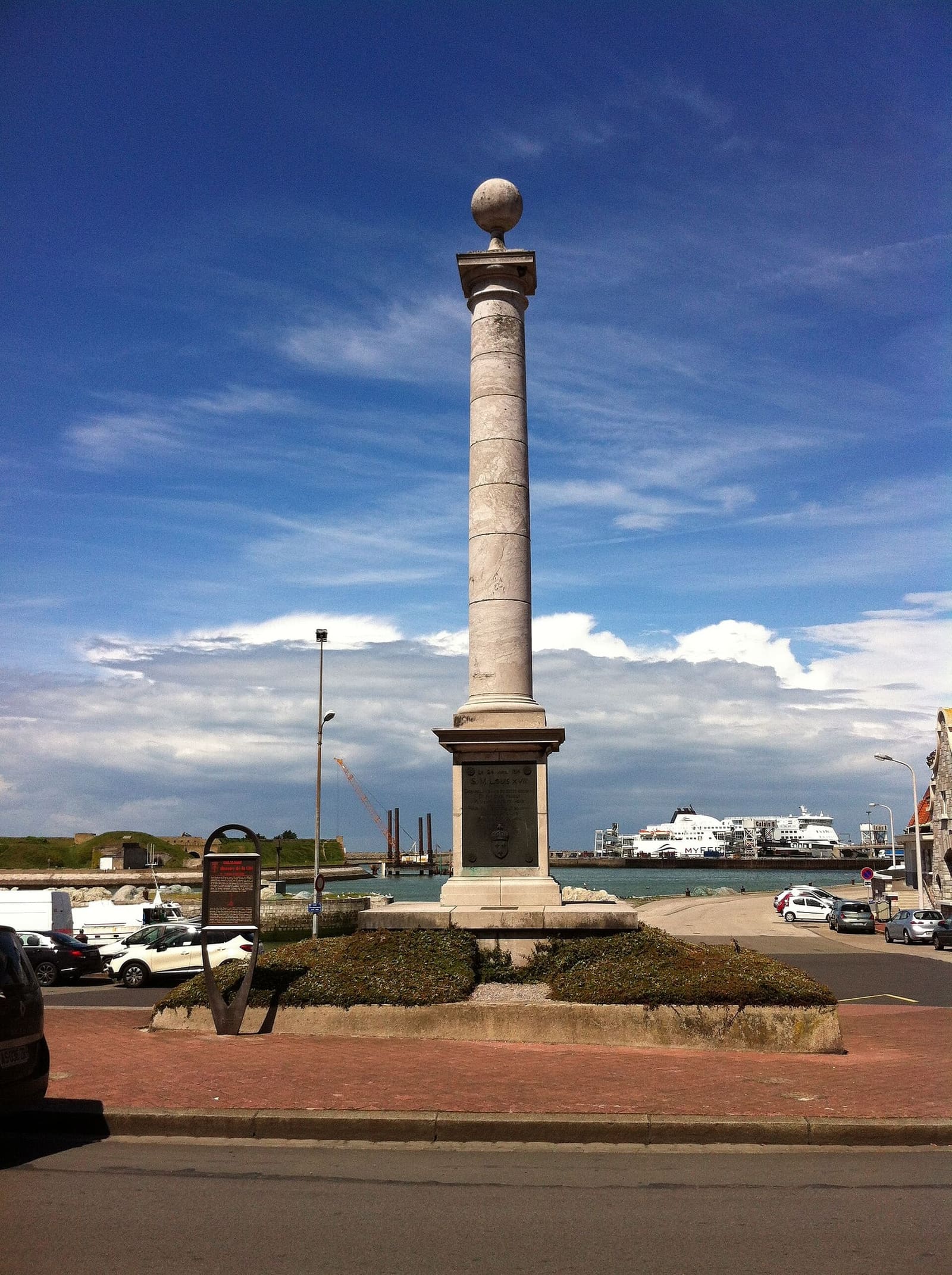 la colonna che ricorda lo sbarco di Luigi XVIII nel 1814, con un traghetto nel porto dietro