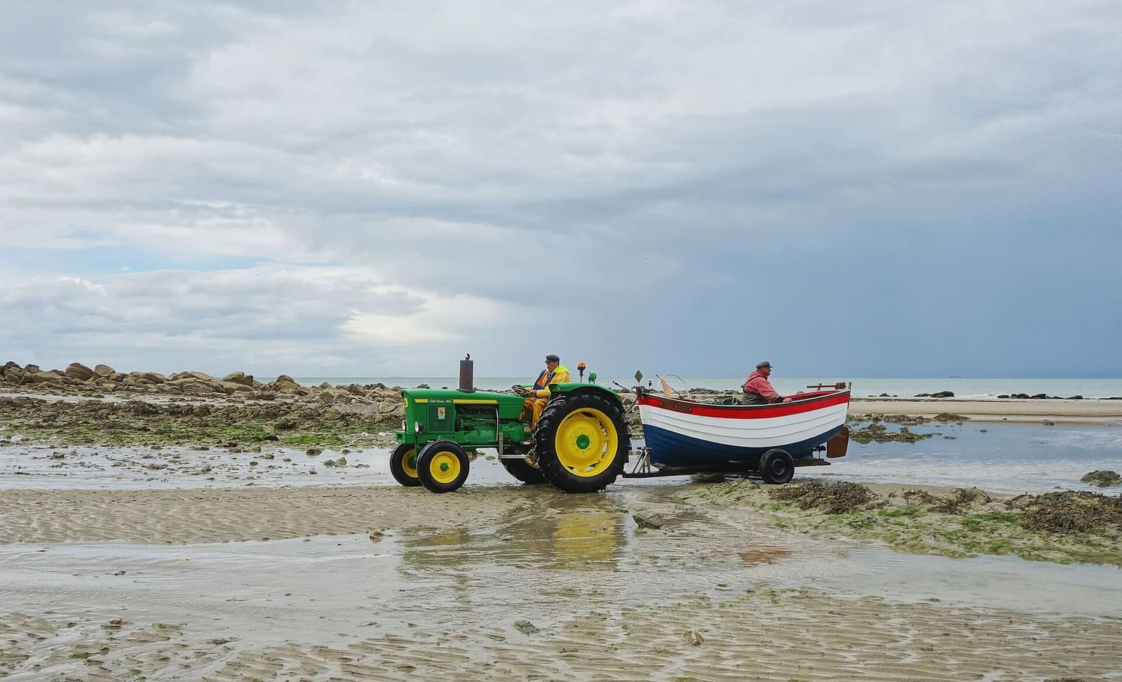 un trattore che tira un flobart, la barca da spiaggia dei pescatori, sulla spiaggia del Gris-Nez