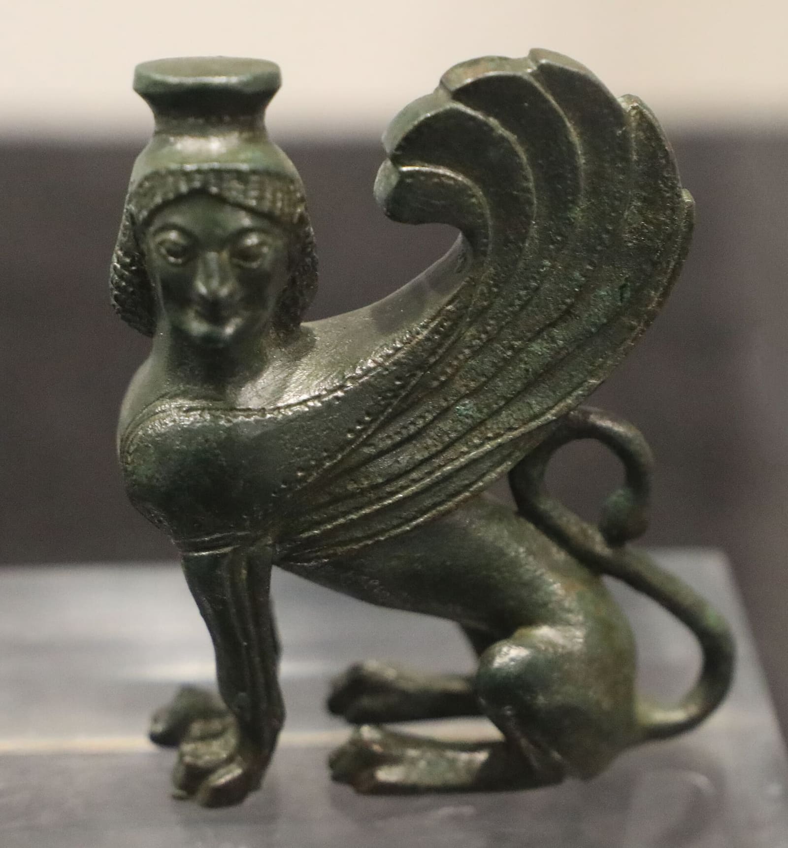 a seated bronze sphinx, from the sanctuary