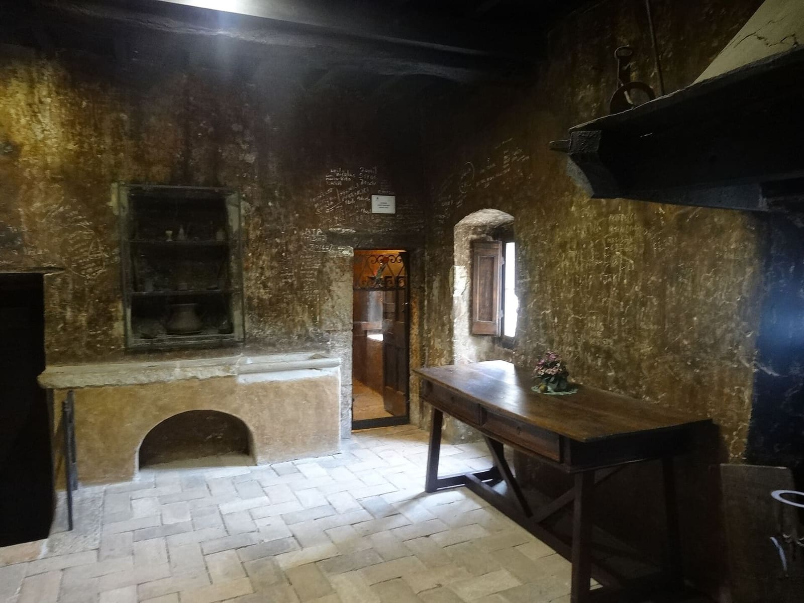 una stanza della casa natale di Santa Rita, con il camino e il tavolo di legno