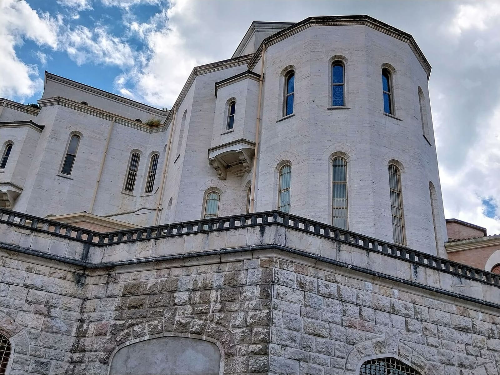 il fianco e l'abside della basilica di Santa Rita, sopra il basamento di pietra