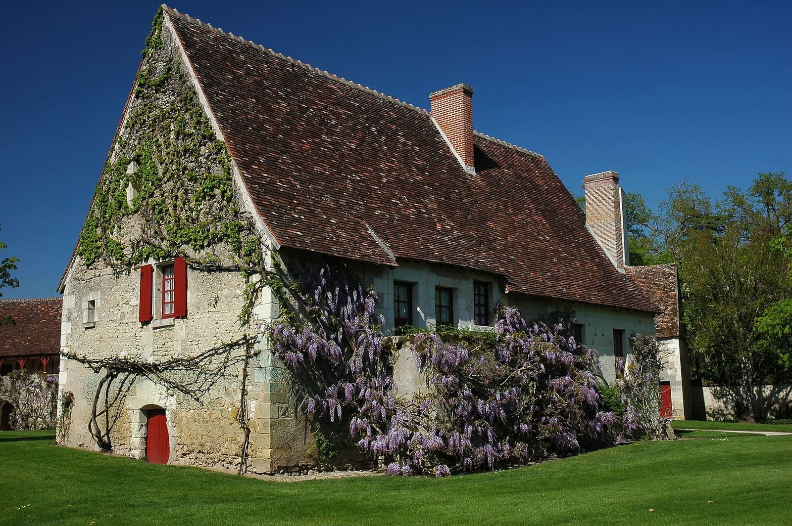 une maison de la ferme du XVIe siècle, avec la glycine en fleurs, en avril