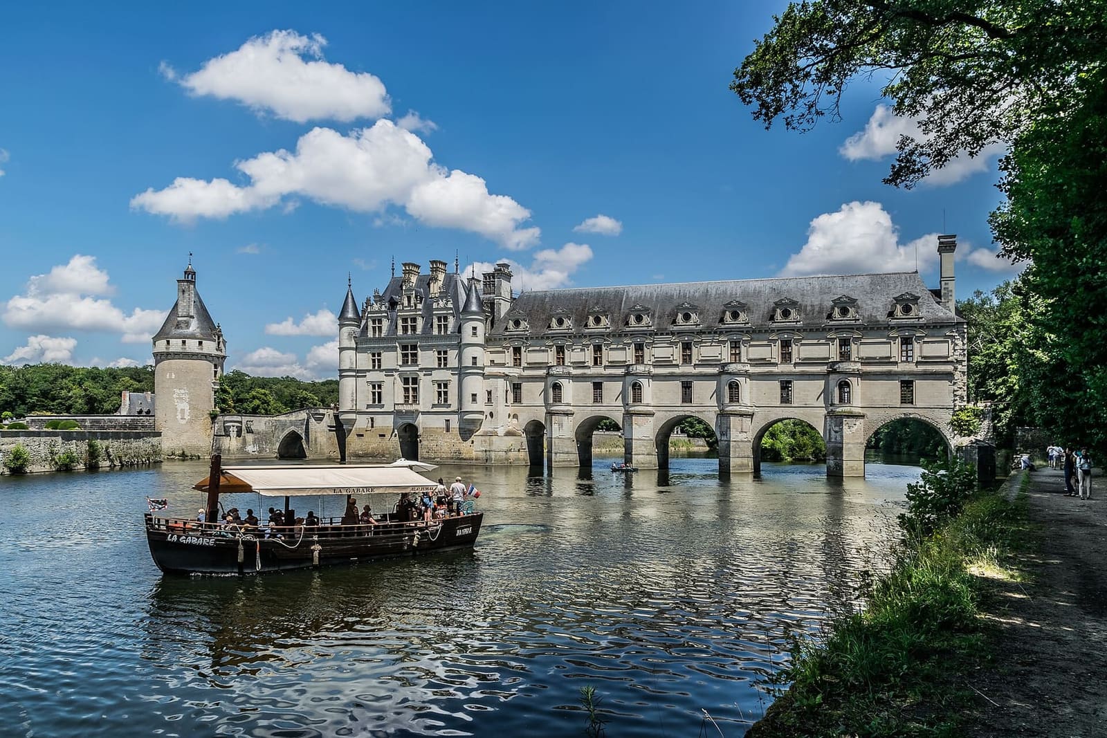 la galerie du château sur le Cher, avec la tour des Marques à gauche et un bateau sur la rivière