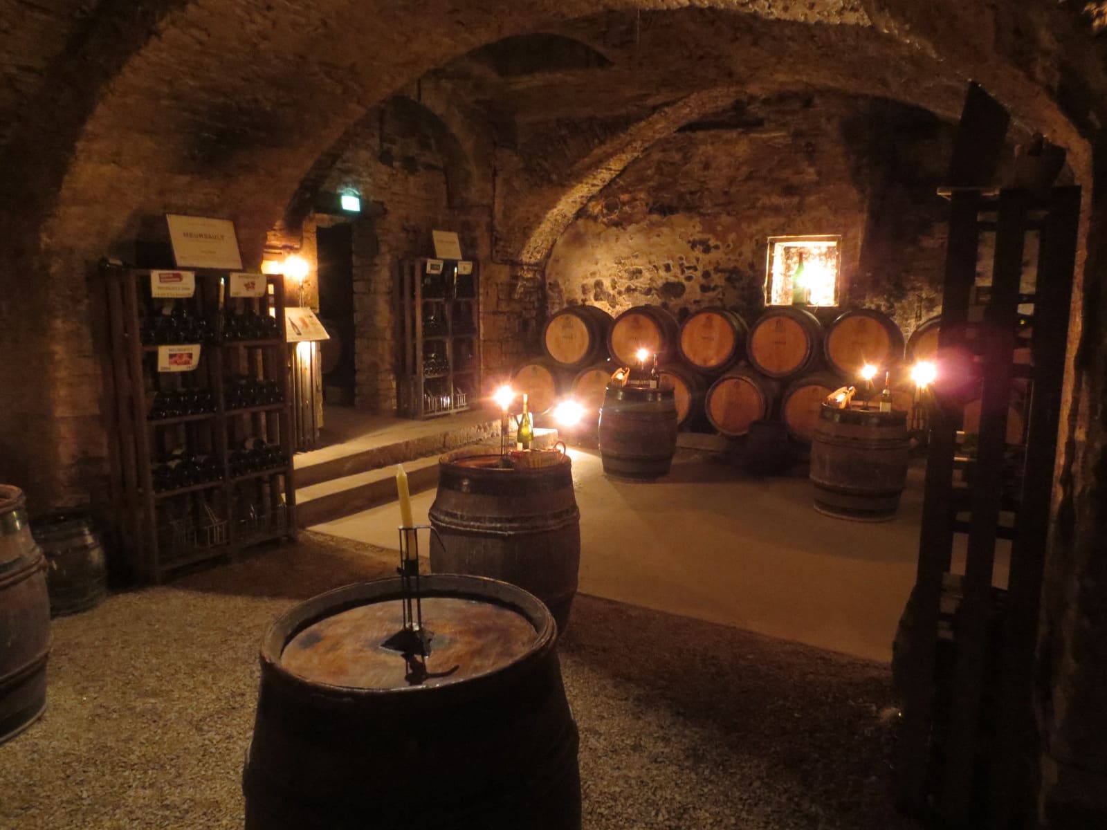 una sala delle cantine a lume di candela, con le botti in fondo