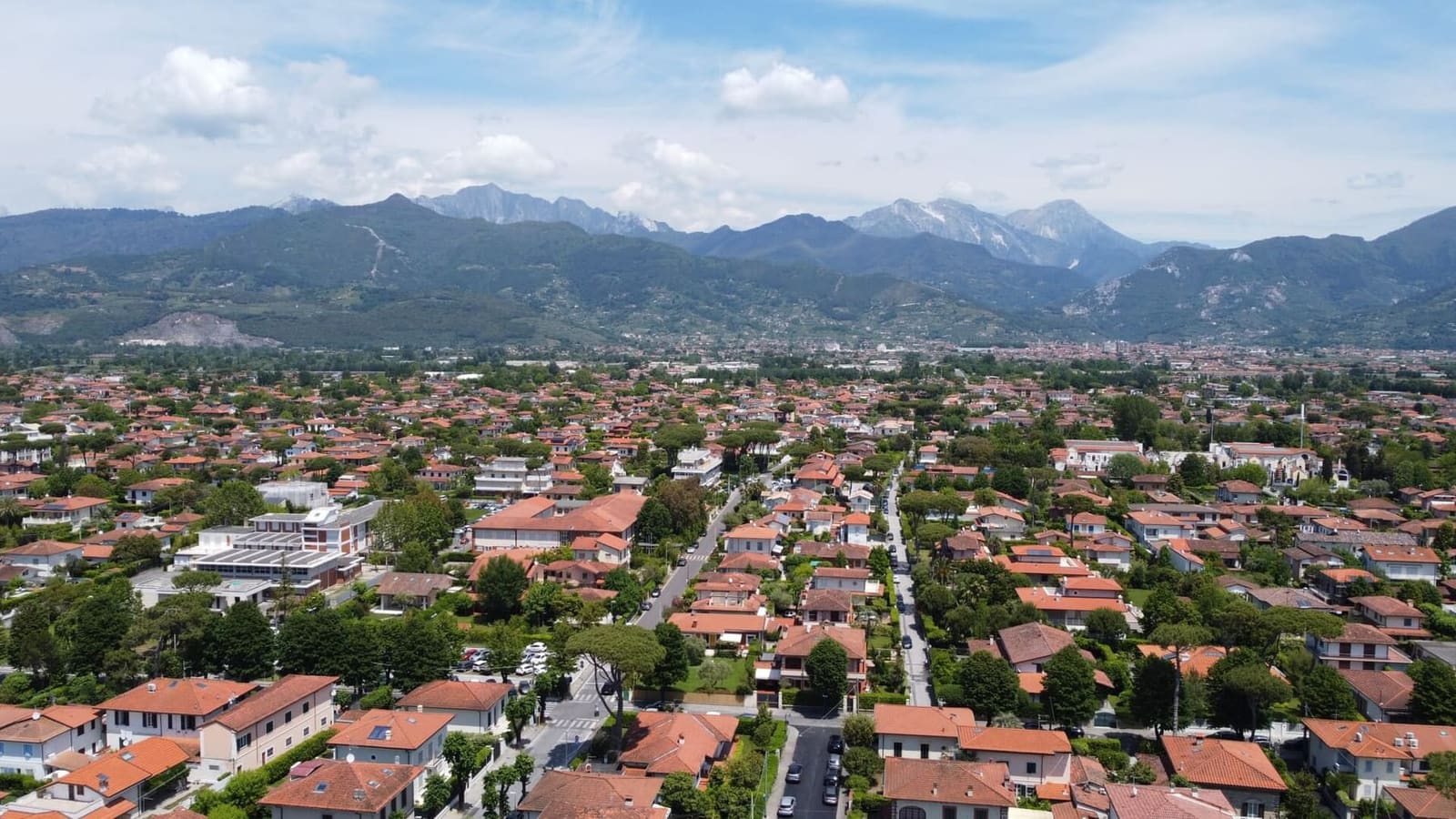 die Häuser im Grün von Forte dei Marmi unter den Apuanischen Alpen, von oben gesehen