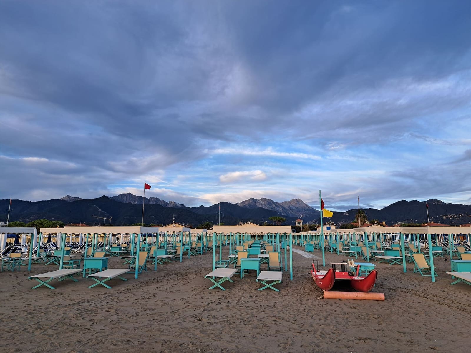 die Strandbäder mit den Zelten und ein Pattino auf dem Sand, unter den Apuanischen Alpen
