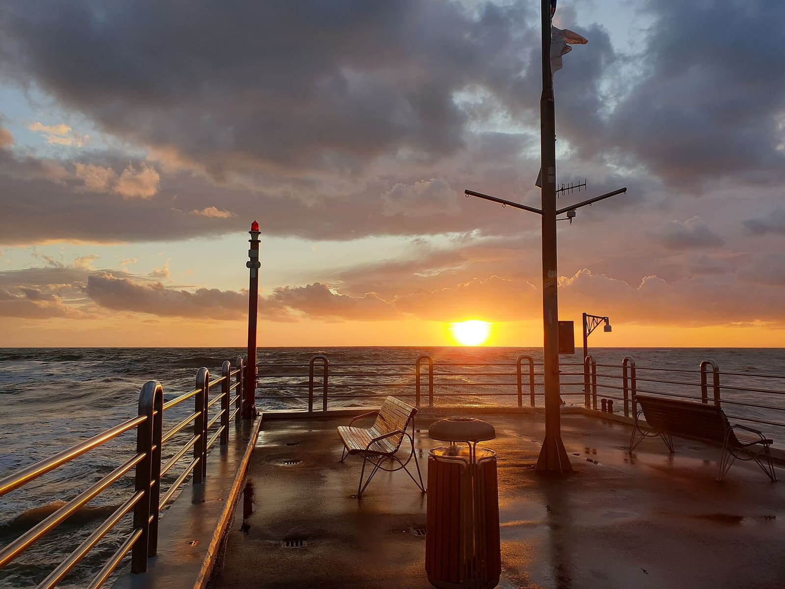 der Sonnenuntergang über dem Meer, vom Kopf der Seebrücke aus