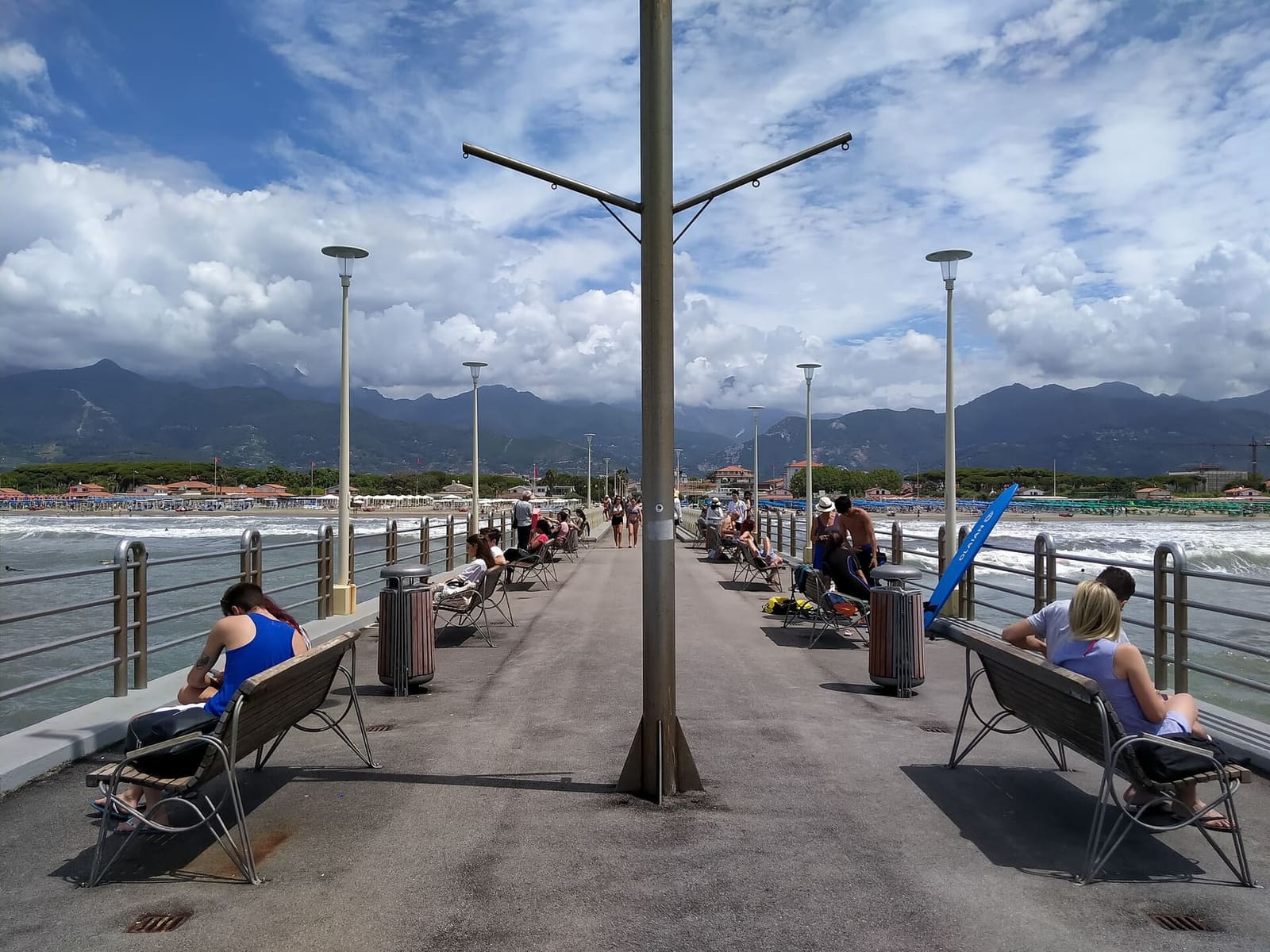 die Bänke entlang der Seebrücke, mit den Apuanischen Alpen zwischen den Wolken
