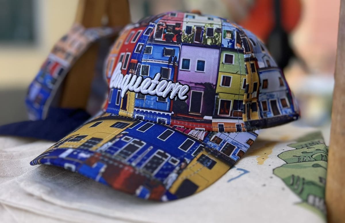 un cappellino con le case colorate stampate sopra, su una bancarella di souvenir
