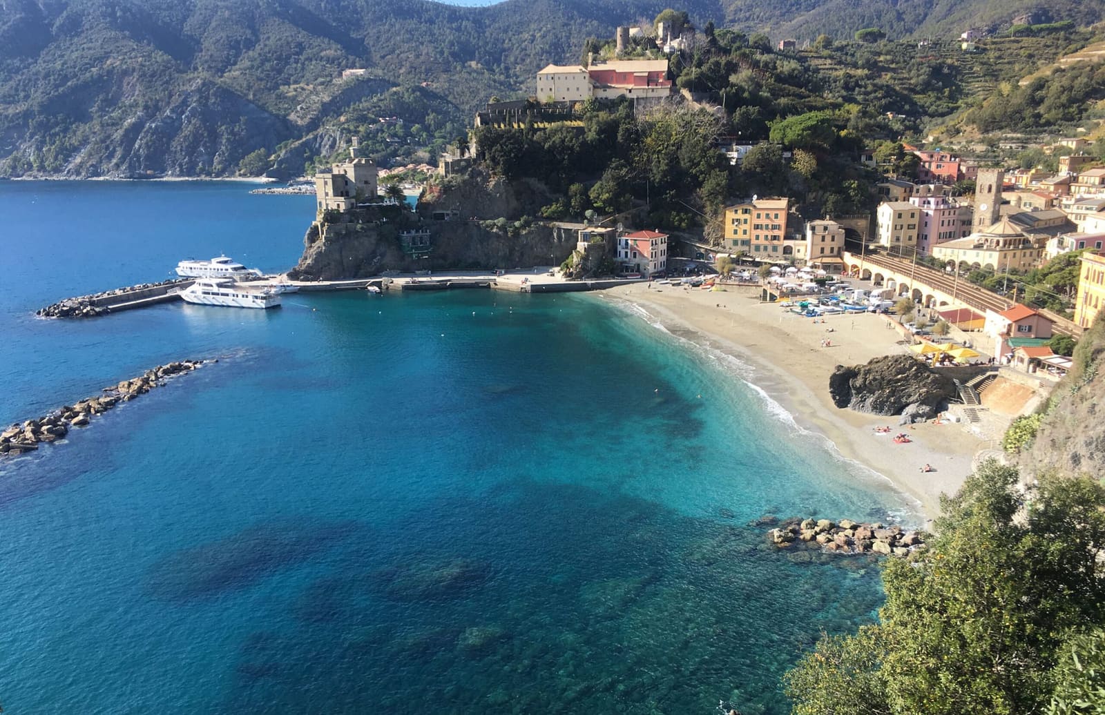 la baia di Monterosso dal sentiero, con la spiaggia, il molo e il castello sul promontorio