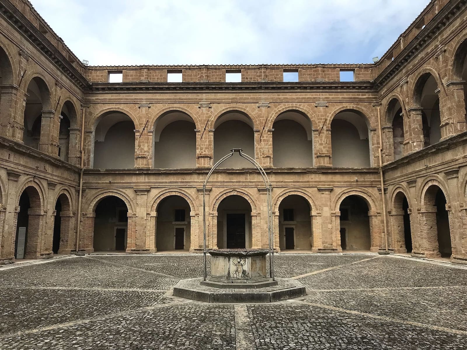 il cortile d'onore del forte, con i due ordini di arcate e il pozzo in mezzo al selciato