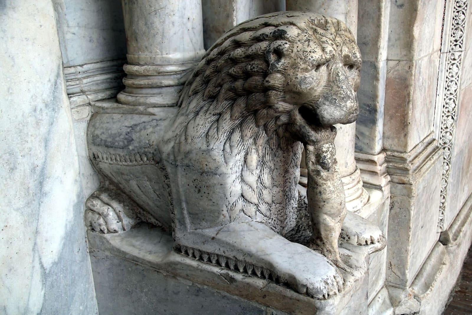 uno dei leoni di marmo accucciati ai lati del portale centrale, sotto le colonnine