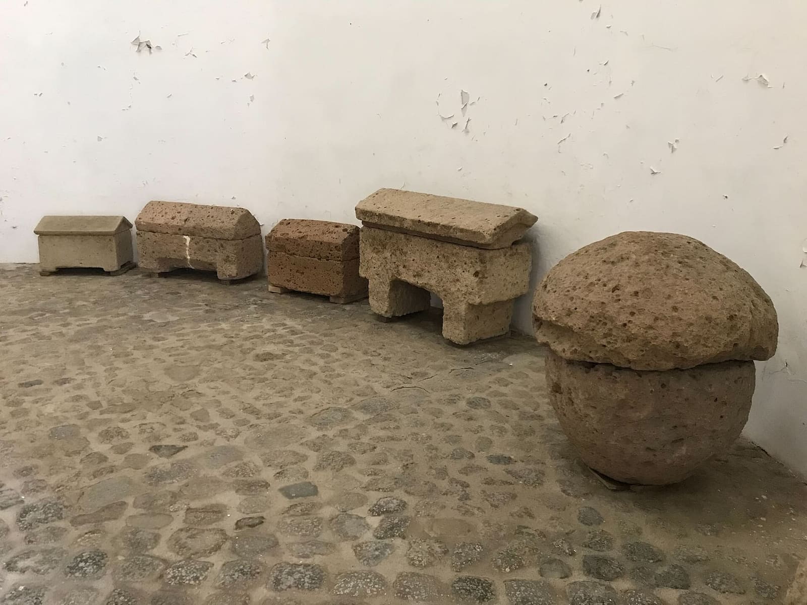 le urne cinerarie falische di tufo raccolte in un angolo del forte, con i coperchi a tetto e uno tondo