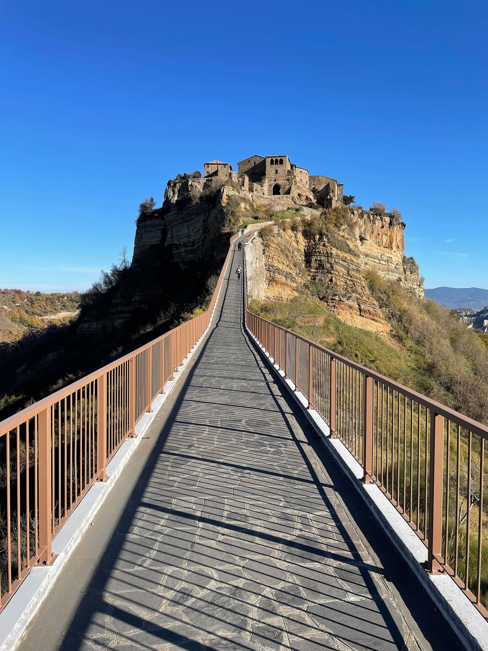 il ponte pedonale che sale verso Porta di Santa Maria, con il borgo in cima alla rupe di tufo