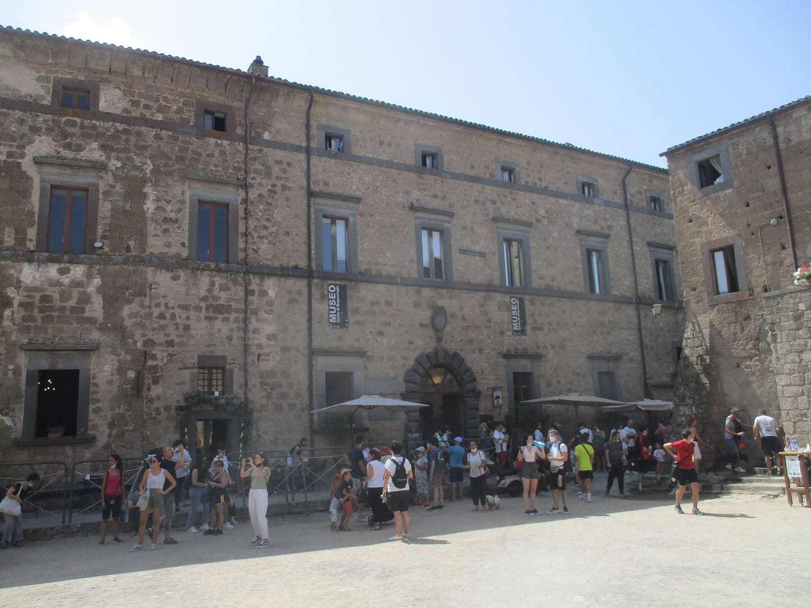 Palazzo Alemanni con gli stendardi del museo geologico e delle frane, e la fila all'ingresso
