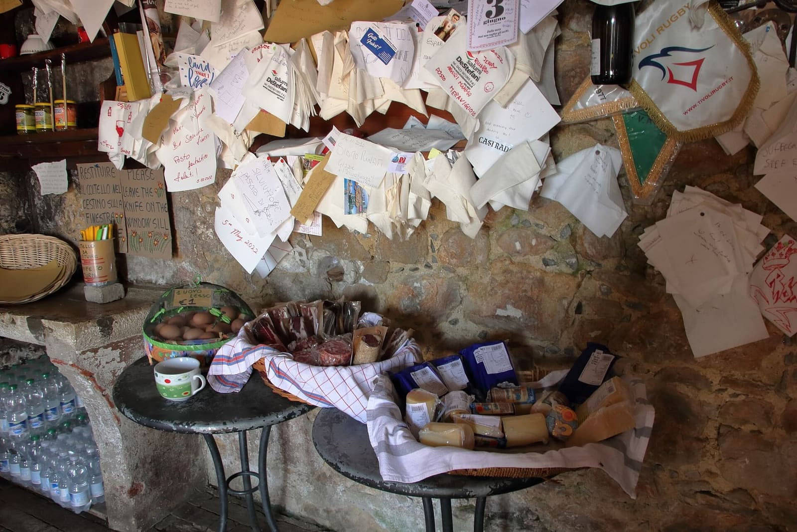 il banco dell'Osteria senz'oste, con il formaggio, le uova e i biglietti lasciati dai passanti