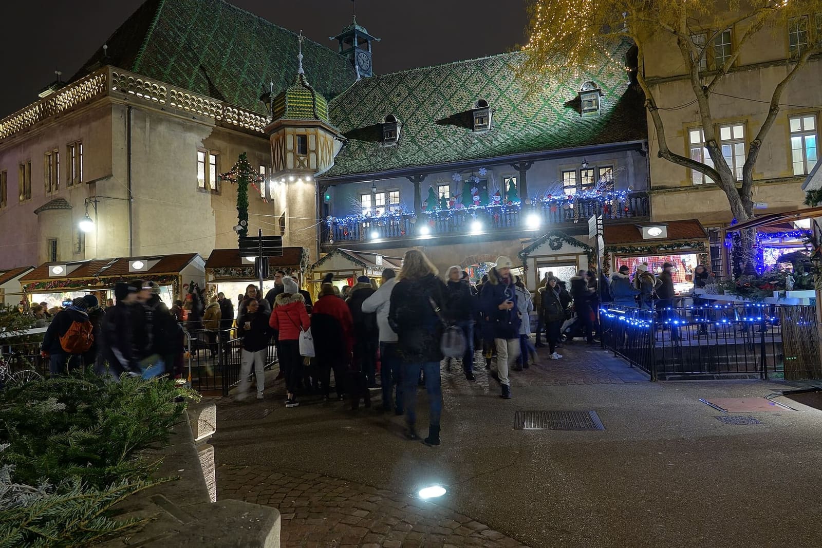 il mercatino della place de l'Ancienne Douane la sera, con il Koïfhus illuminato