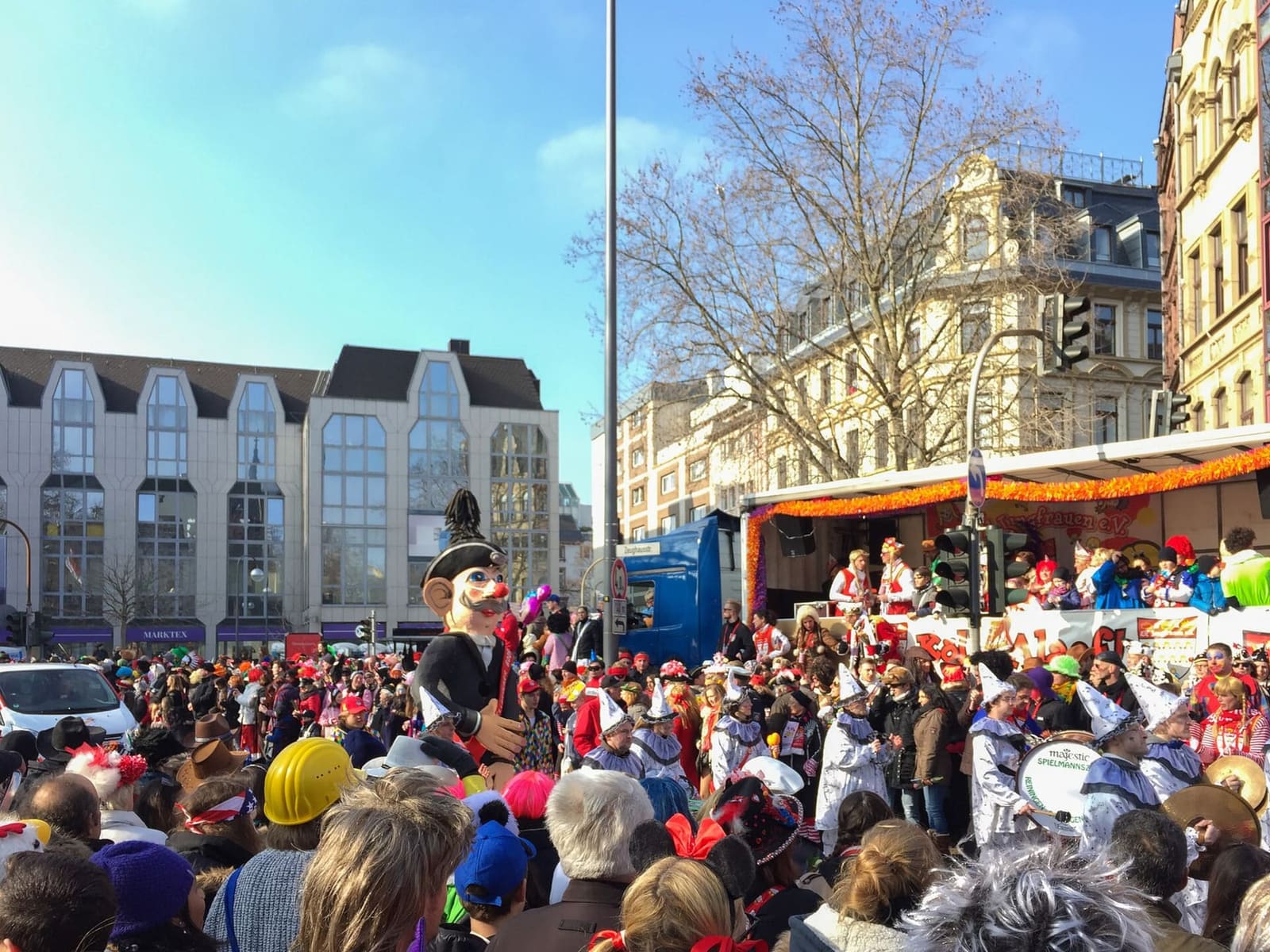 la folla in maschera lungo il percorso del corteo del Rosenmontag, in una giornata di sole