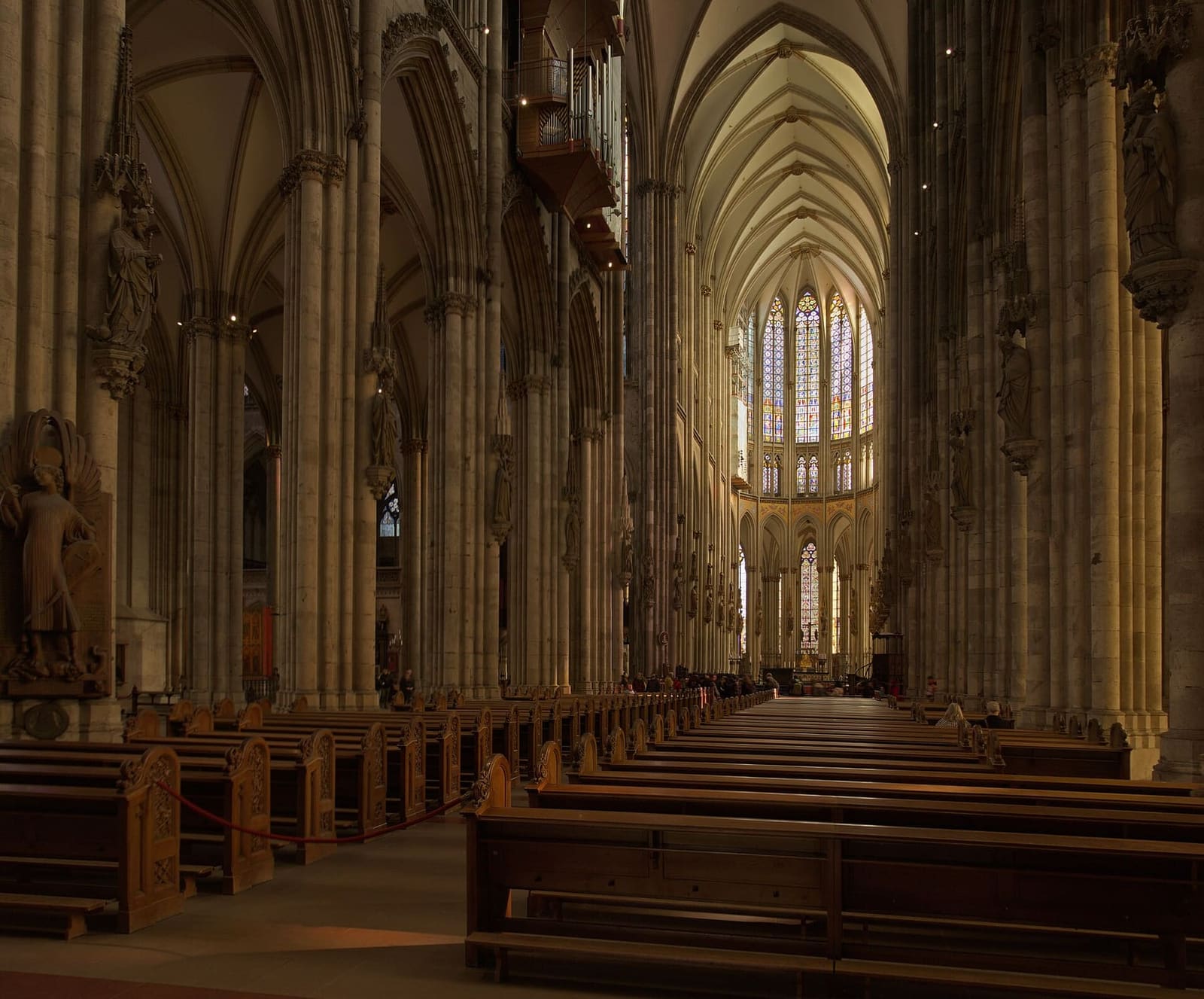 la navata centrale del Duomo con le panche, verso il coro illuminato dalle vetrate