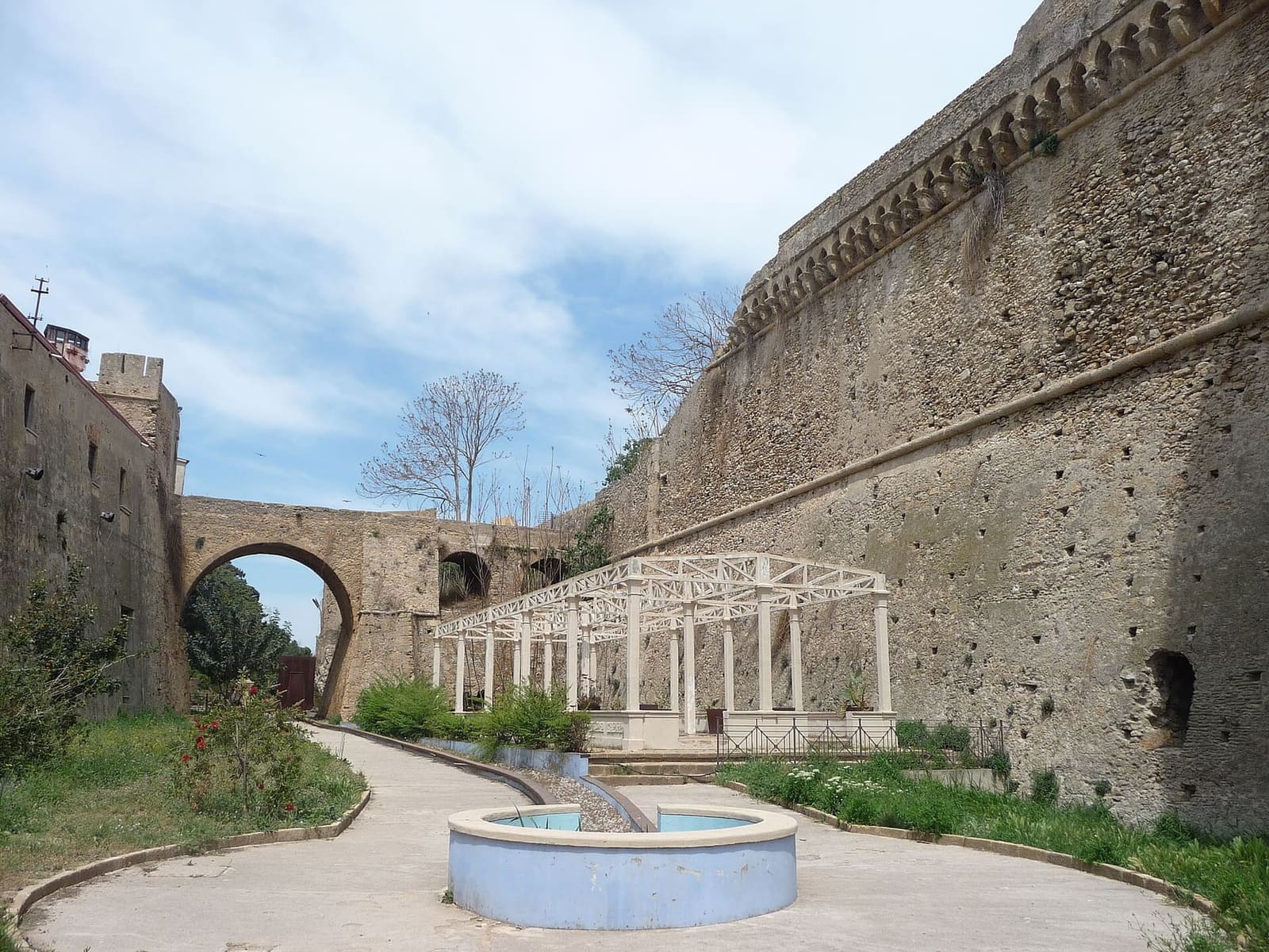 il giardino nel fossato del castello, con la fontana e il ponte in fondo