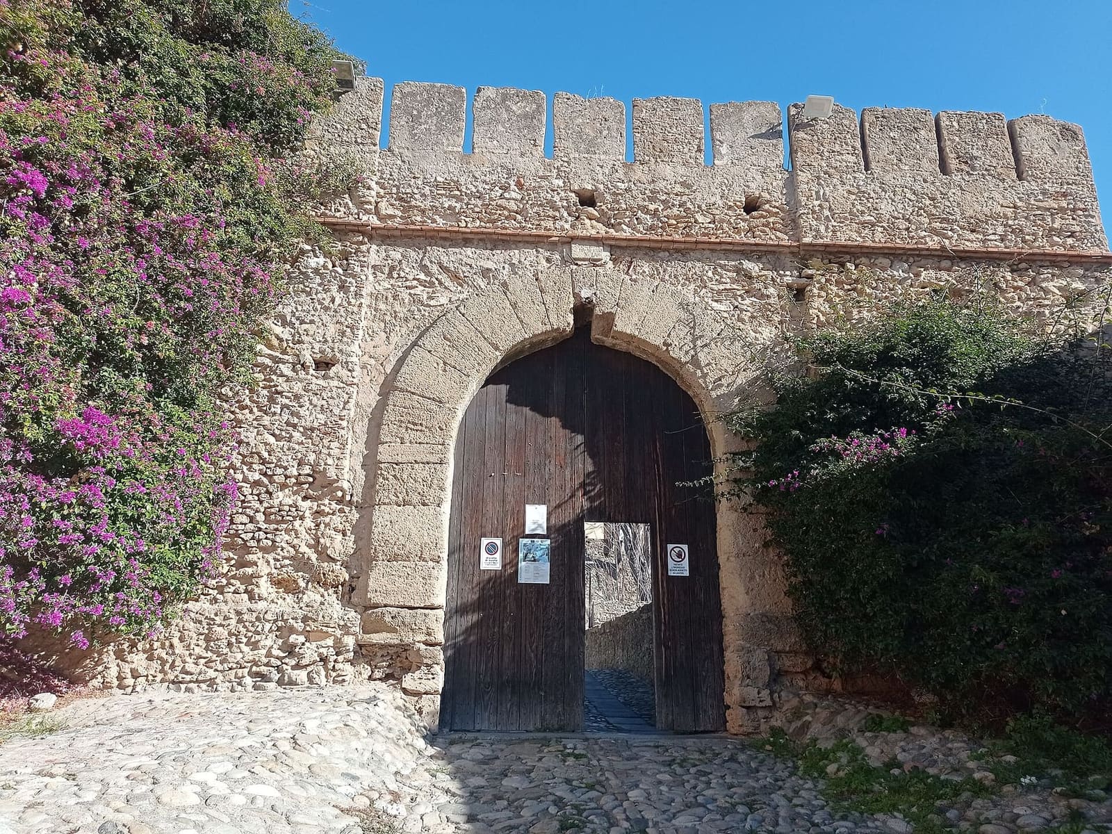 il portone d'ingresso del castello, fra le buganvillee
