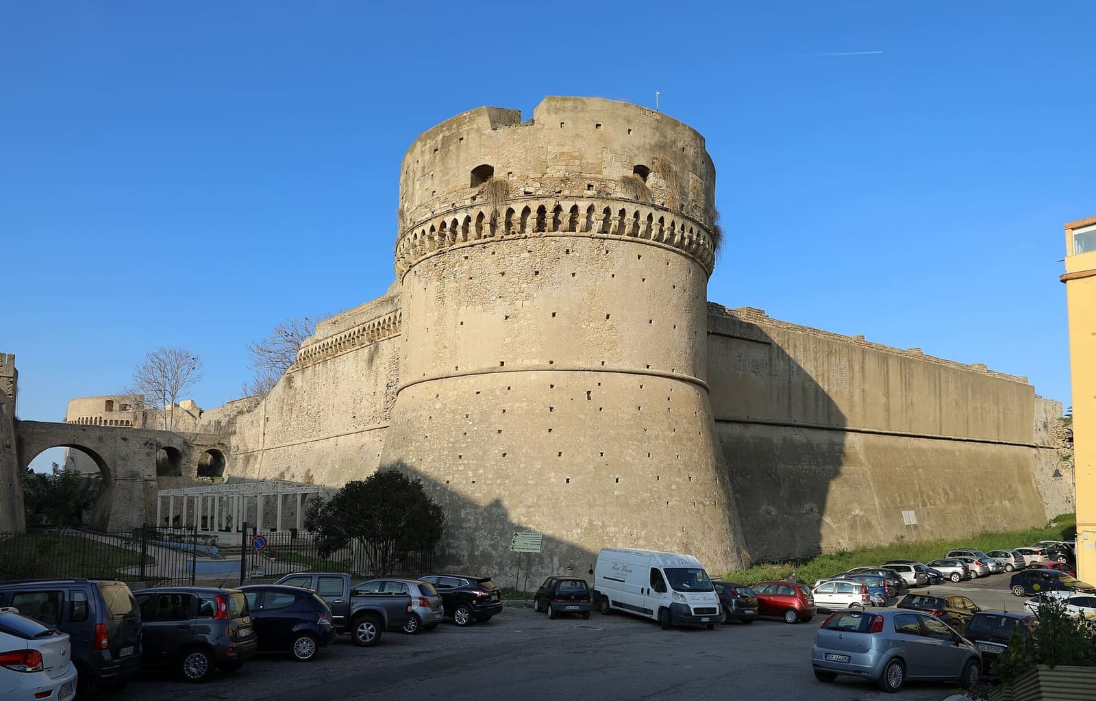 un torrione del Castello di Carlo V, sopra le auto parcheggiate