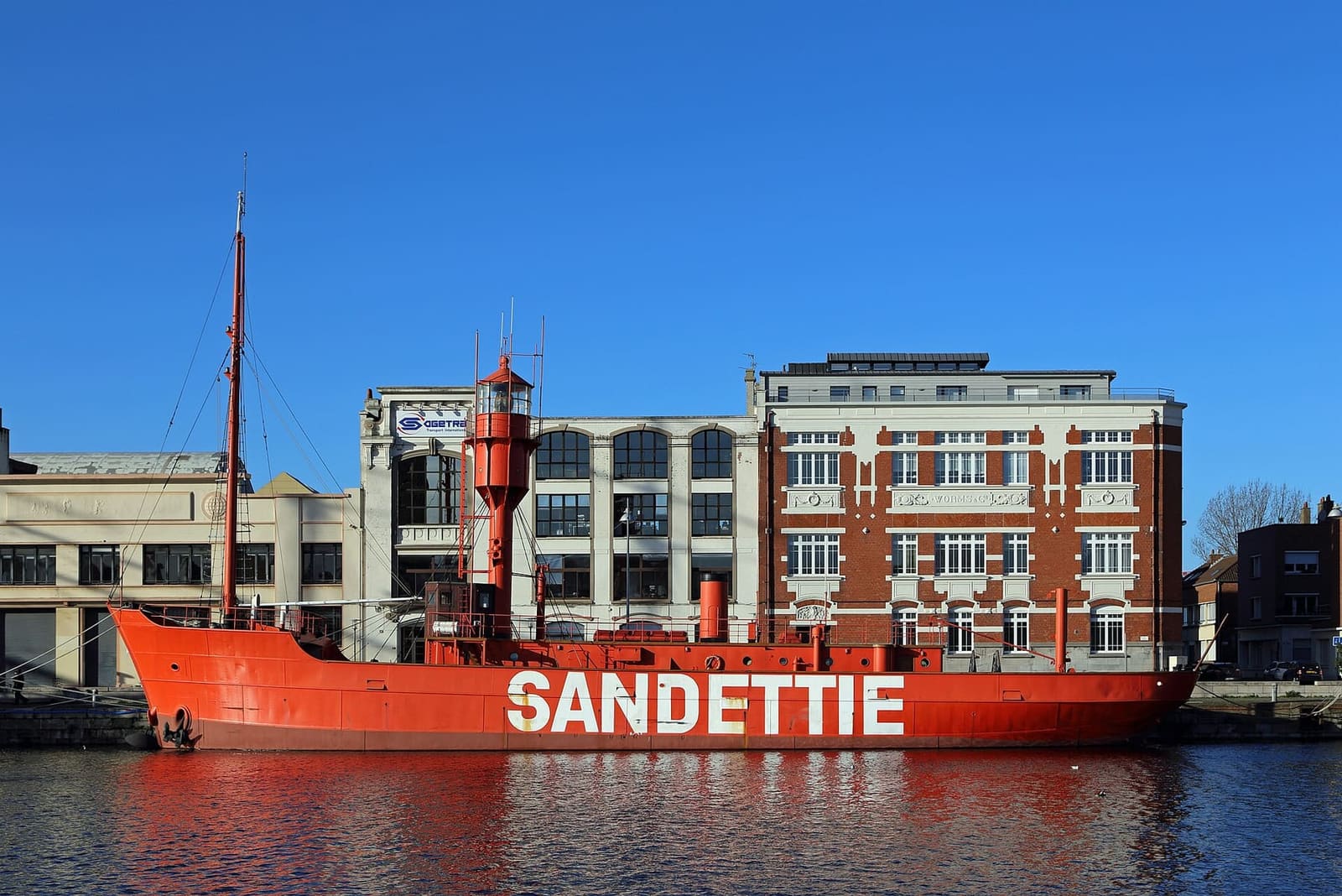 the red Sandettié lightship moored in the basin under a blue sky
