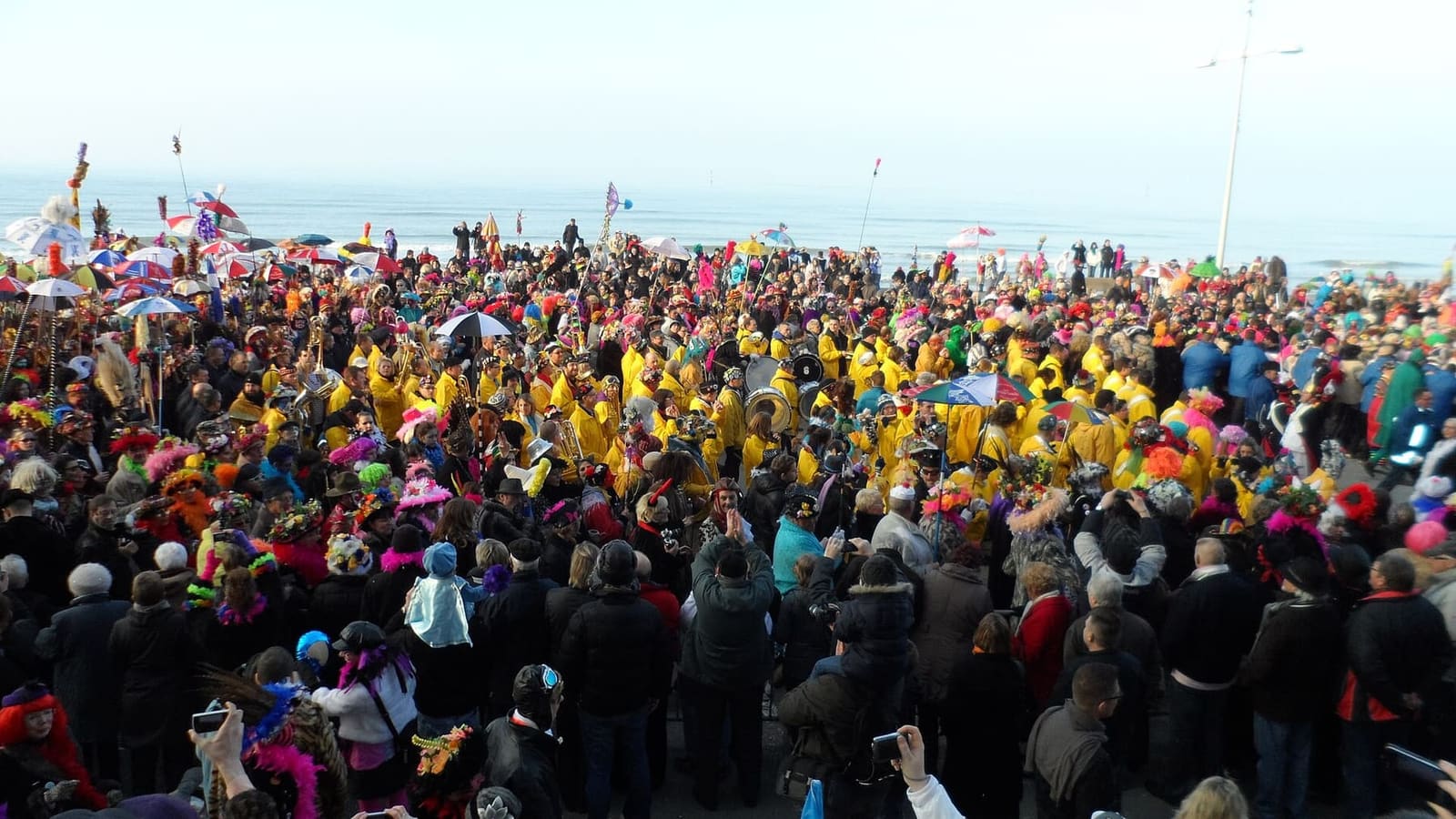 the clique and the costumed crowd on the promenade of Malo-les-Bains, with the sea behind, during the carnival