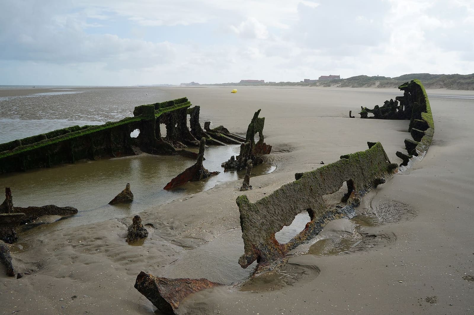 the plates of a wreck on the beach at Leffrinckoucke, towards Zuydcoote, with the dunes behind